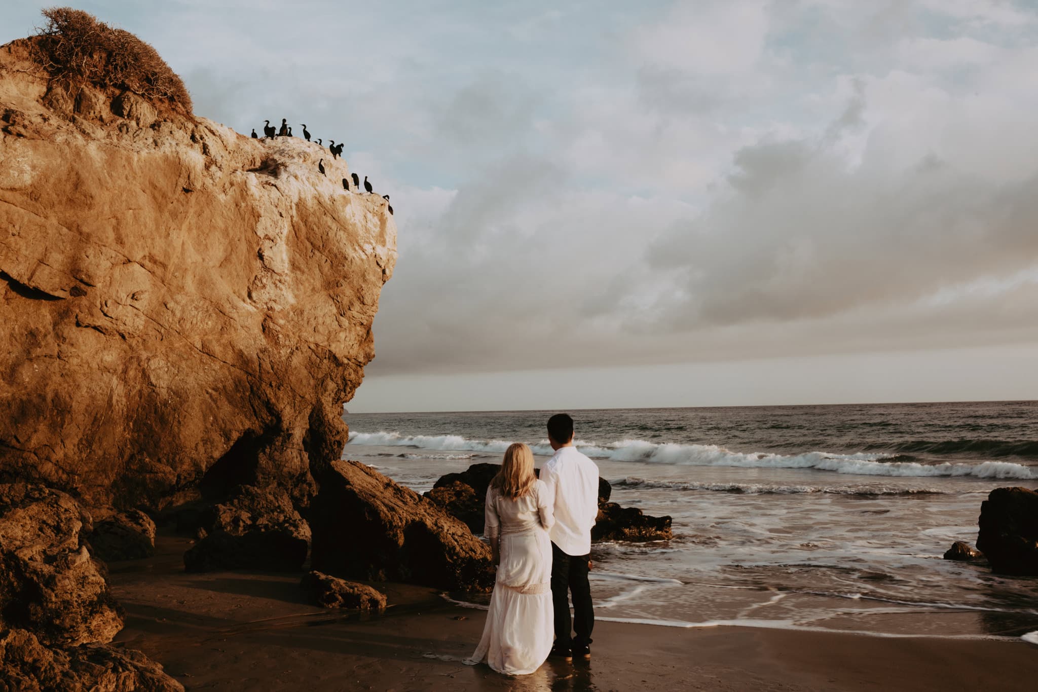 boy and girl look out towards ocean El Matador Beach Engagement Marcela Pulido Portland Wedding Photographer