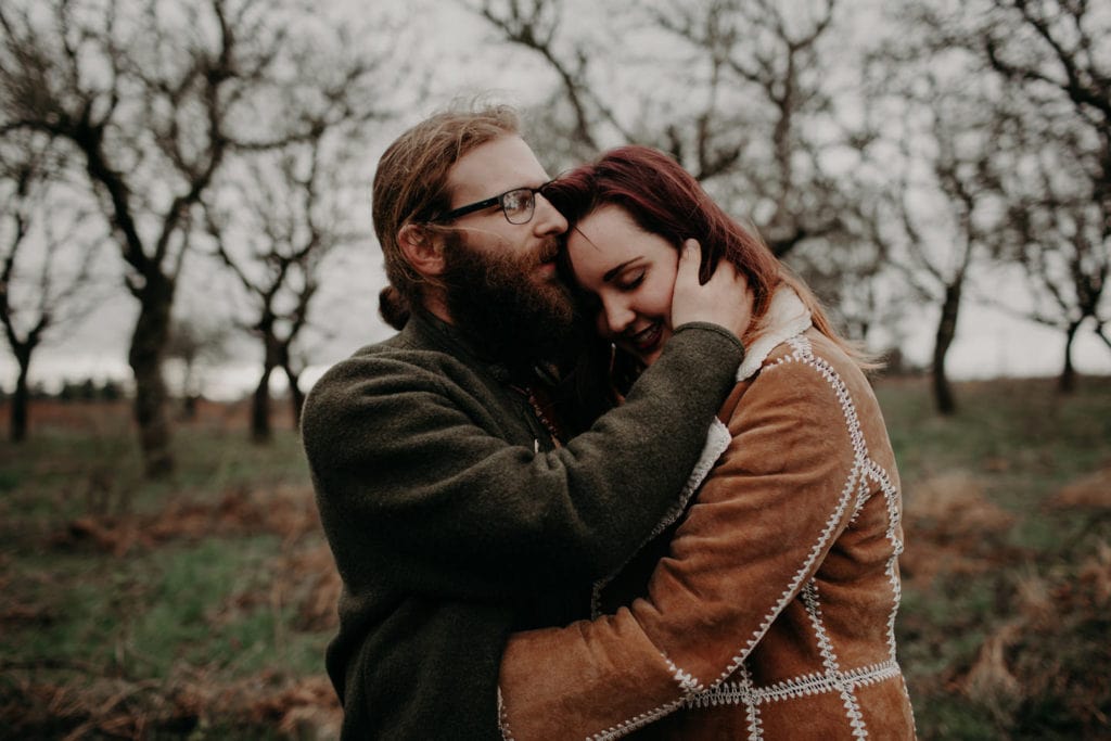 cute boho hippie couple embrace in forest Powell Butte Portland Engagement Photographer by Marcela Pulido Photography Portland Wedding Photographer