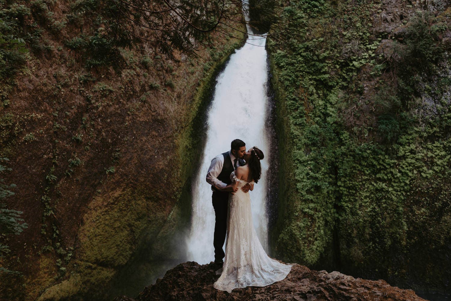 newlywed couple kissing in front of Wahclella Falls Columbia River Gorge elopement