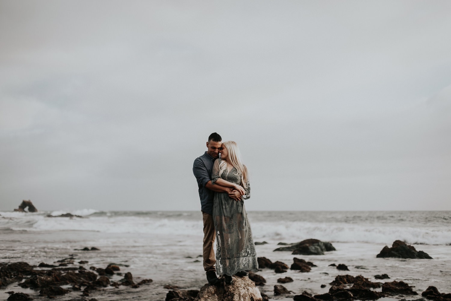 moody affectionate couple on the beach laguna beach engagement photographer