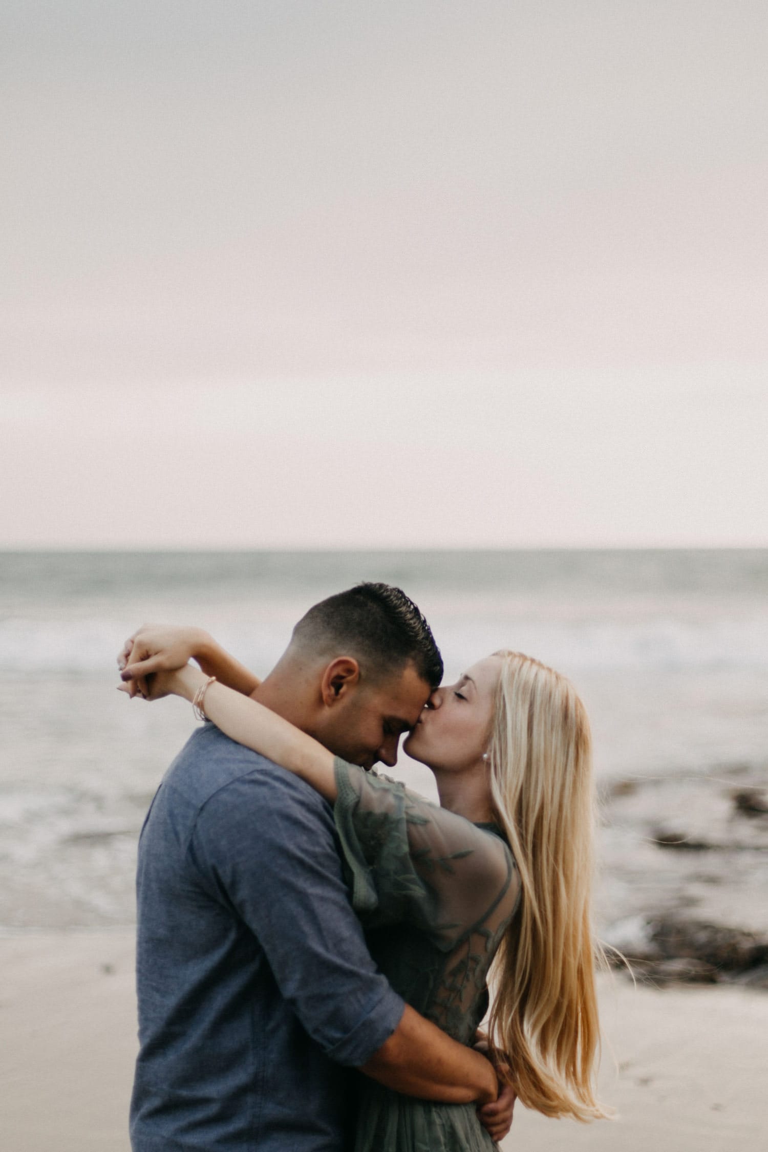 cute couple West Coast sunset girl kissing guy's forehead laguna beach engagement photographer