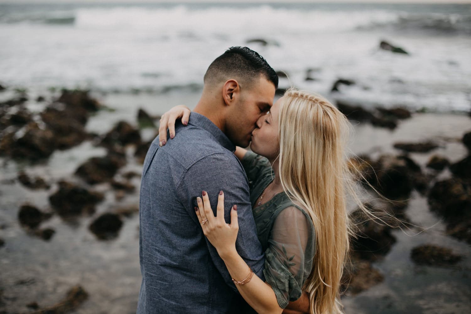 couple holding and kissing one another West Coast California laguna beach engagement photographer