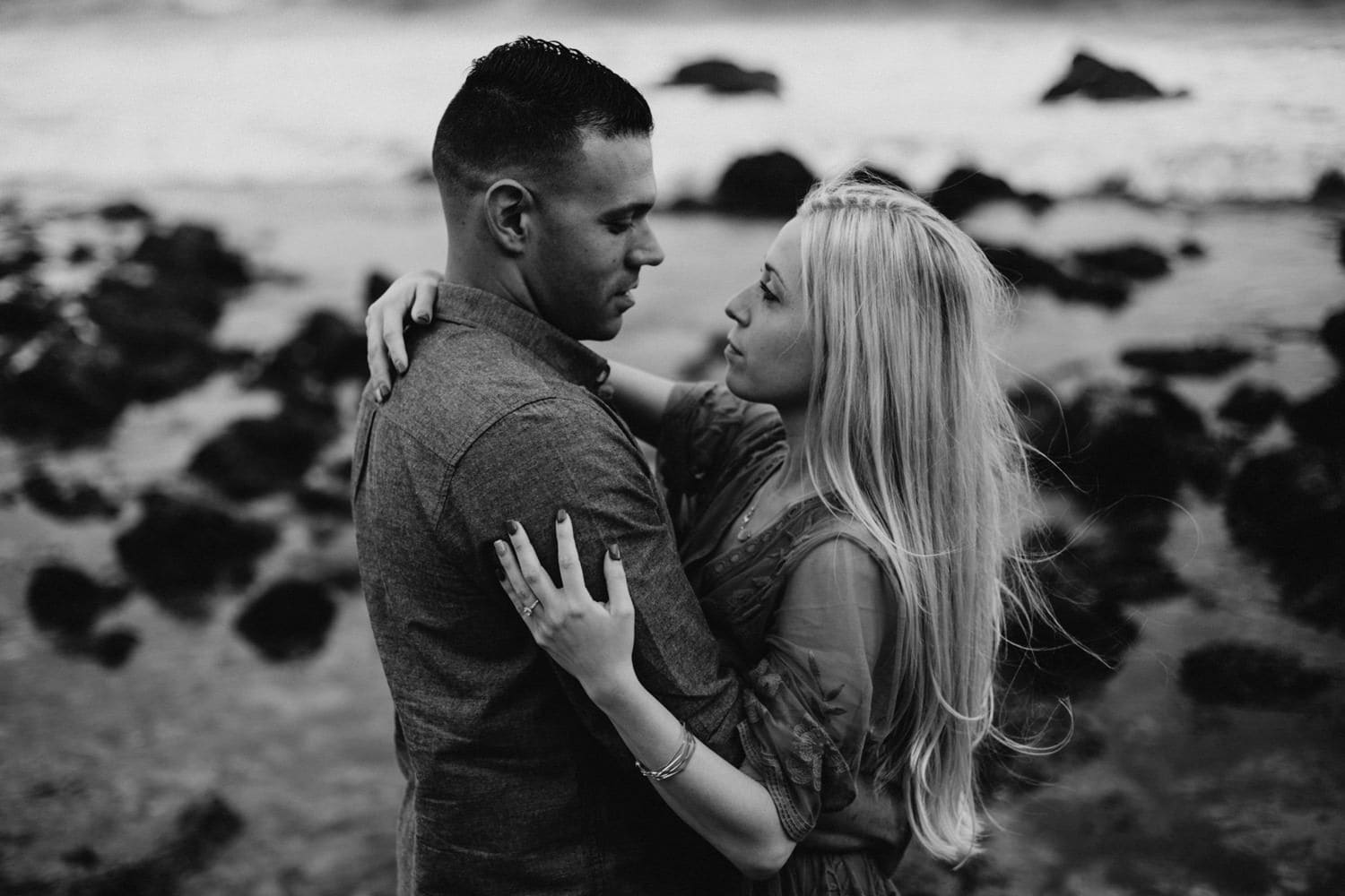 black and white couple gazing lovingly at each other on the West Coast California laguna beach engagement photographer