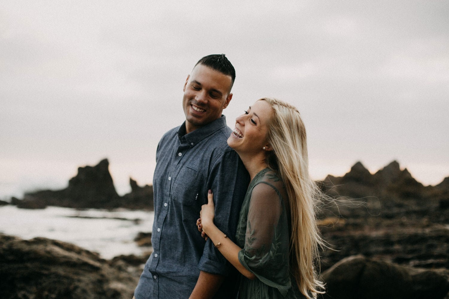 cute blonde couple smiling together West Coast sunset laguna beach engagement photographer