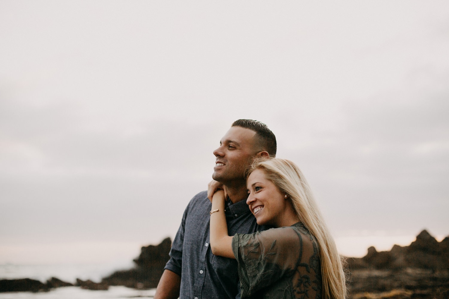 cute blonde couple looking off into distance laguna beach engagement photographer