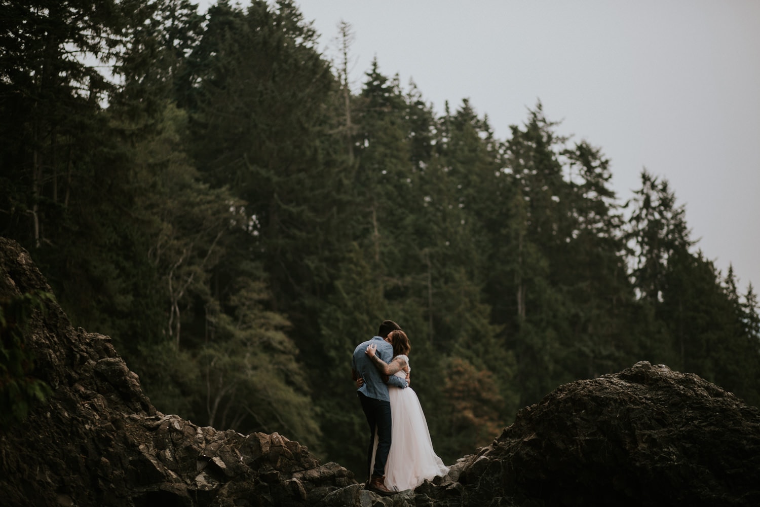 newlywed couple kissing on a rock on the coast of their pacific northwest forest elopement olympic peninsula elopement by marcela pulido portland oregon wedding and elopement photographer