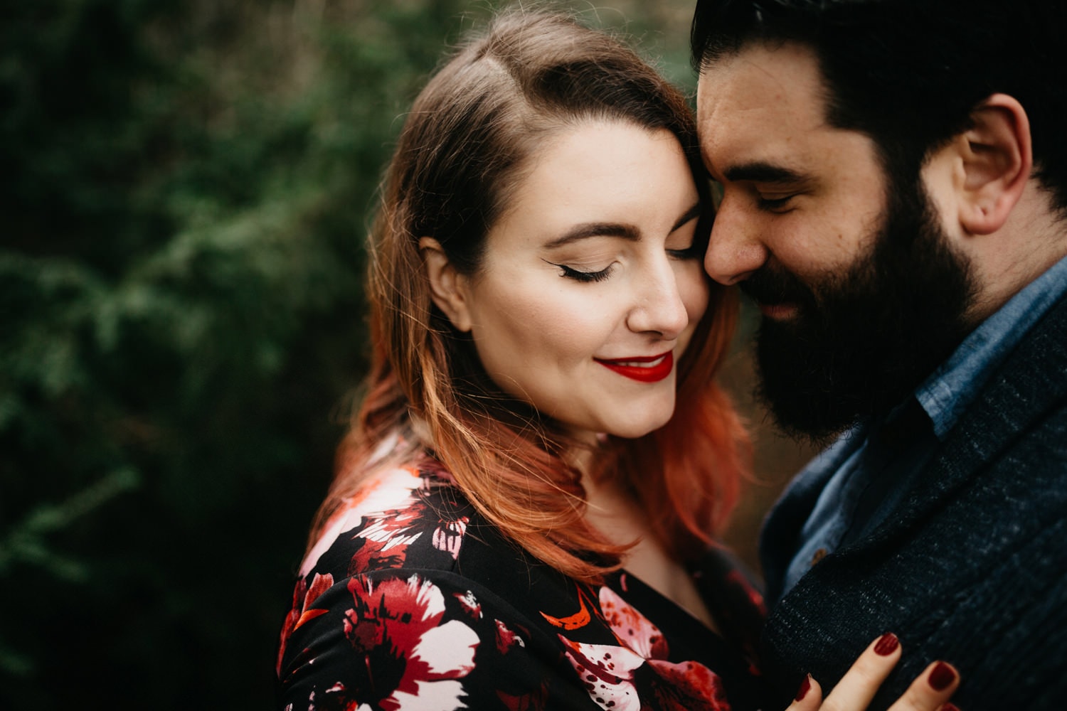 beautiful girl with cat eyeliner and red lips snuggling bearded fiance at Hoyt Arboretum Washington Park engagement in Portland Oregon