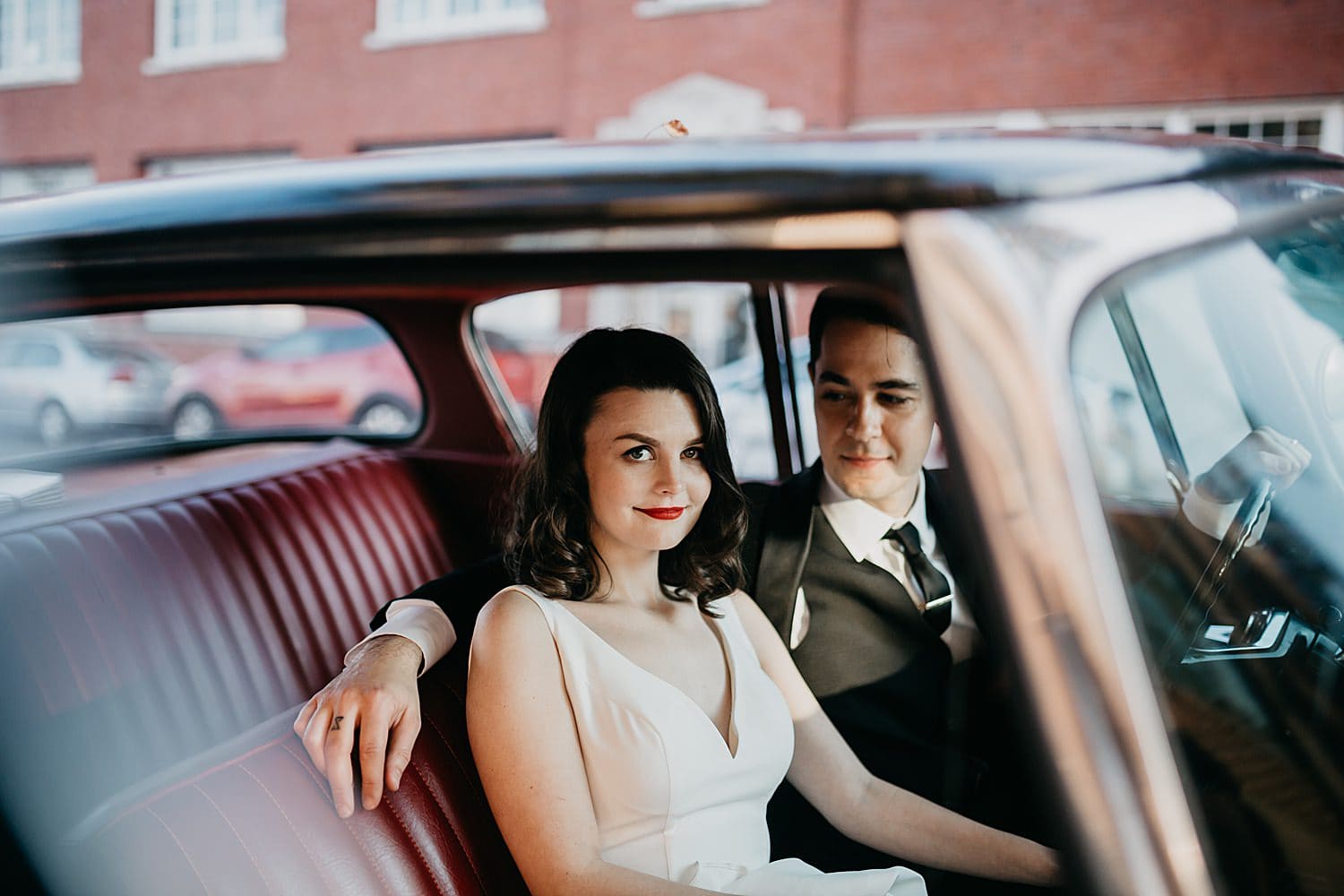 cute newlywed couple sitting in the front seat of a vintage car Melody Ballroom wedding by Marcela Pulido Photography