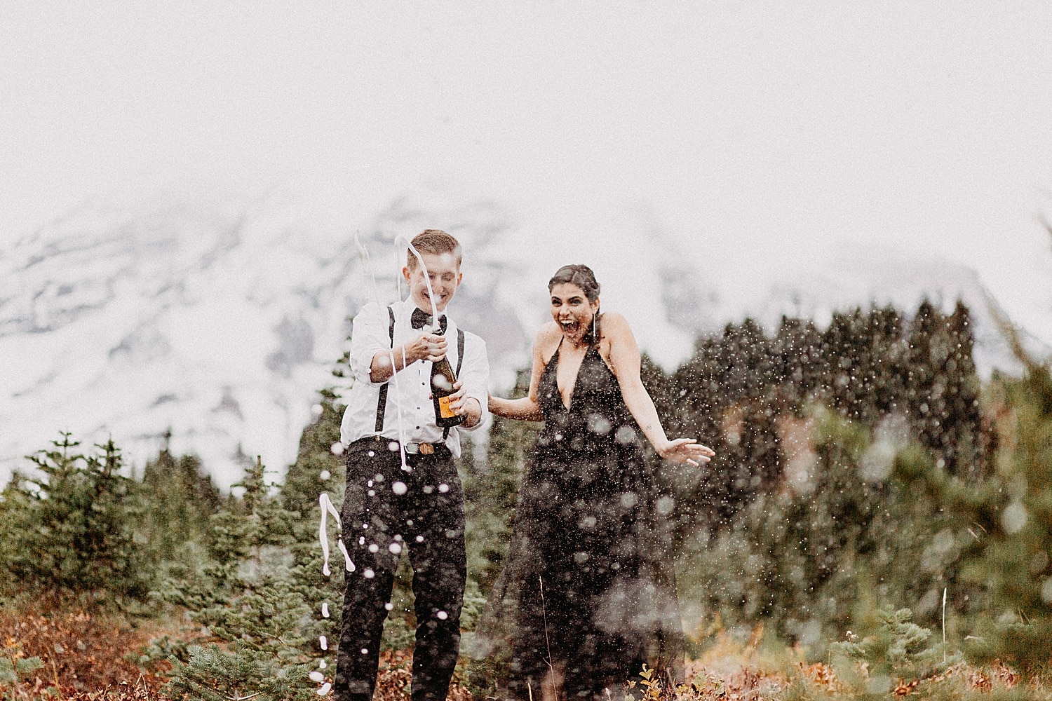 what to wear for engagement photos in portland couple wearing black popping bottle of champagne