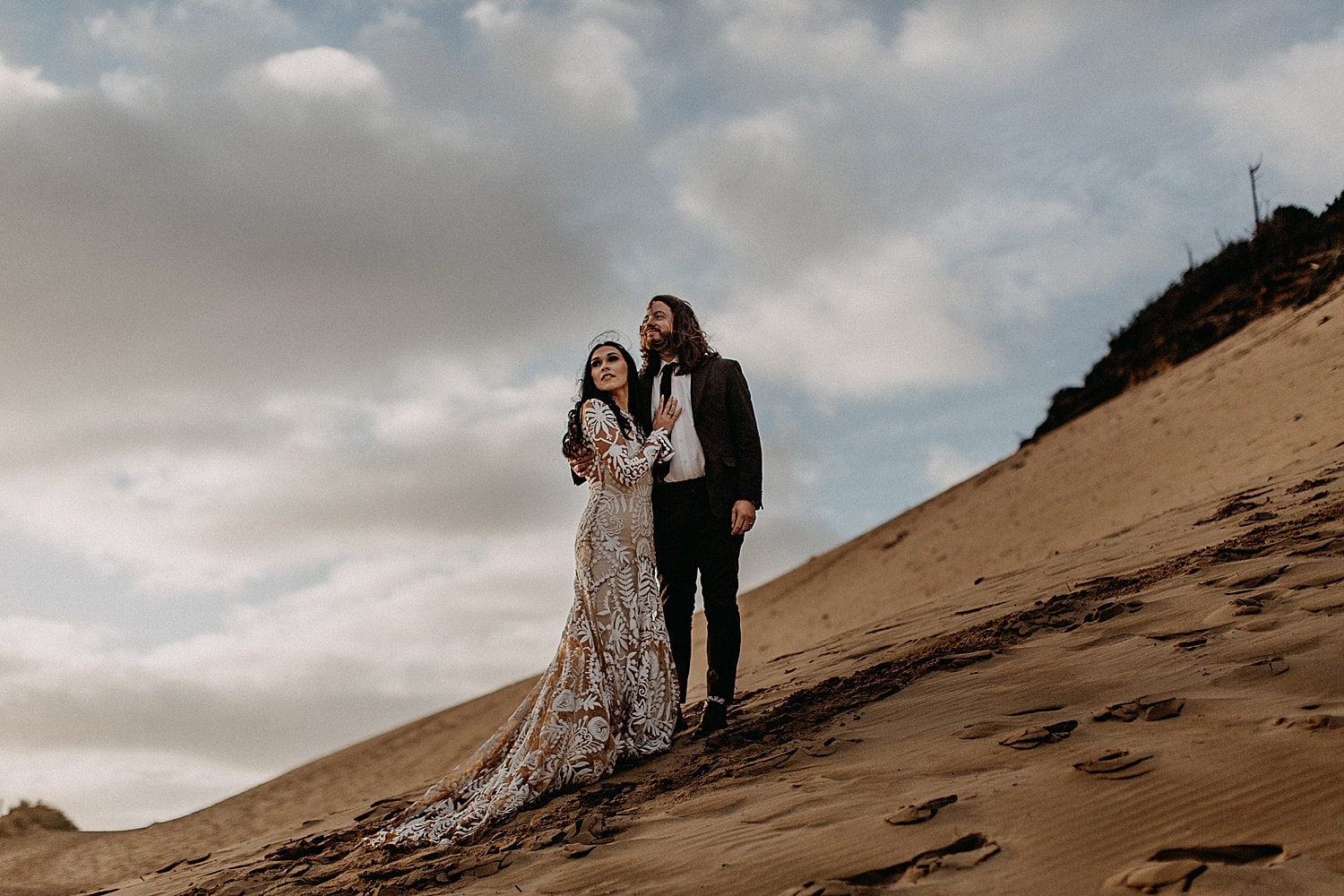 newlywed bride wearing rue de seine gown on a sand dune on the oregon coast