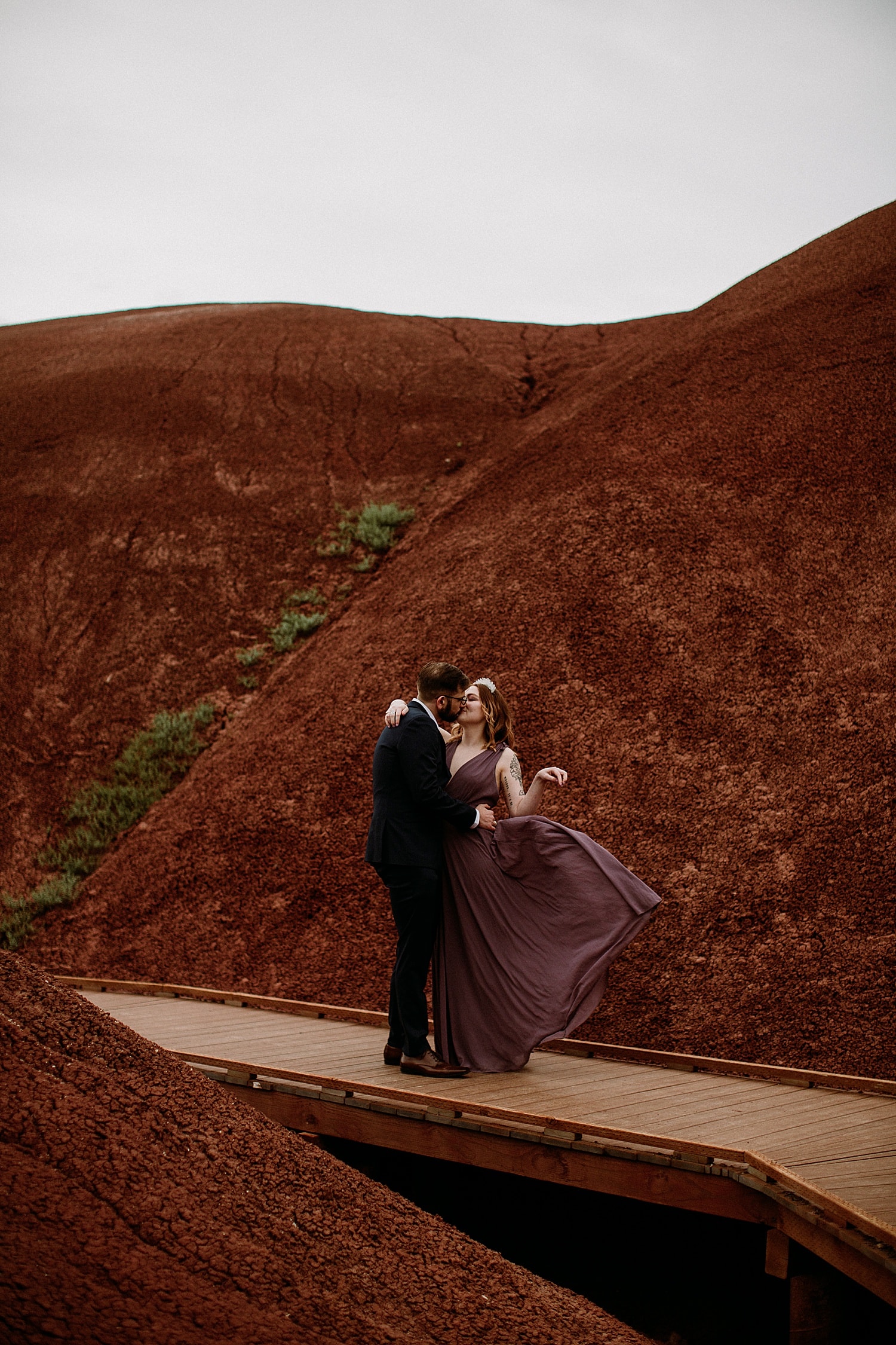 Bride and groom elope in Oregon at the Painted Hills wearing black and lavender dress by Lulus