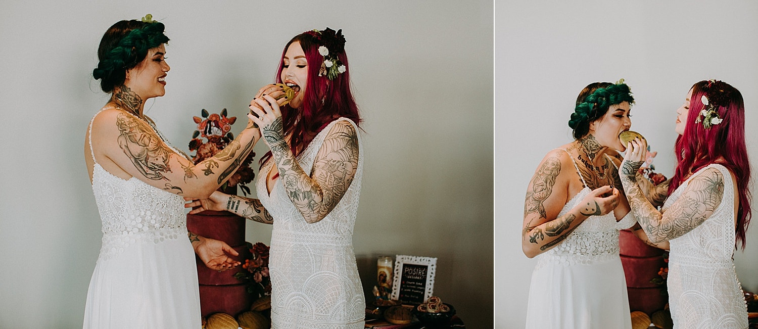 green and pink haired lesbian brides feeding each other mexican conchas photographed by Marcela Pulido Photographer Portland Wedding Photography