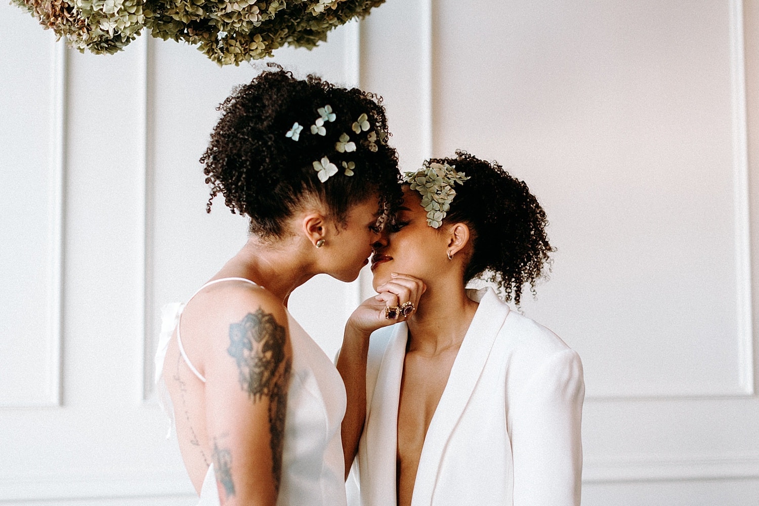 romantic kiss of beautiful same sex lesbian lgbtq+ friendly wedding couple newlywed wearing all white
