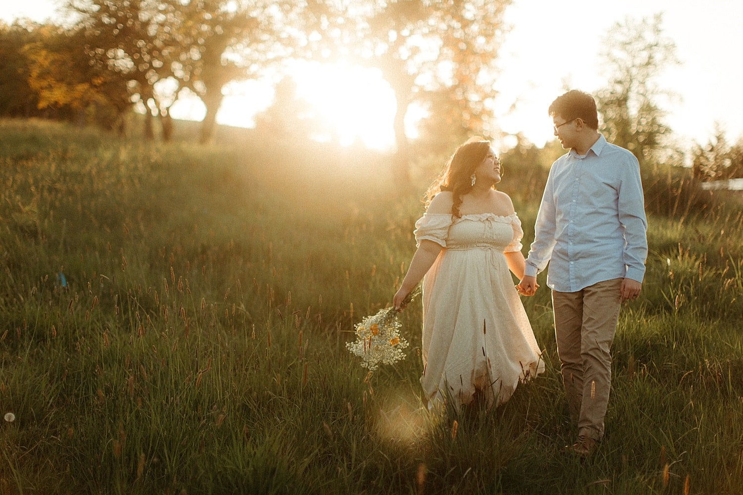 adorable asian couple during golden hour walking in a field cottagecore engagement session